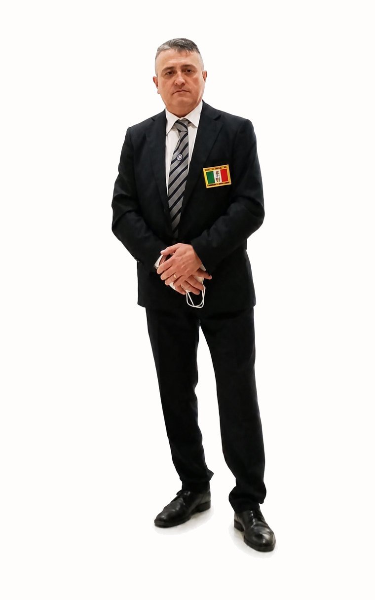 Il Maestro Pier Robertino Cocco in giacca e cravatta, ritratto a figura intera.